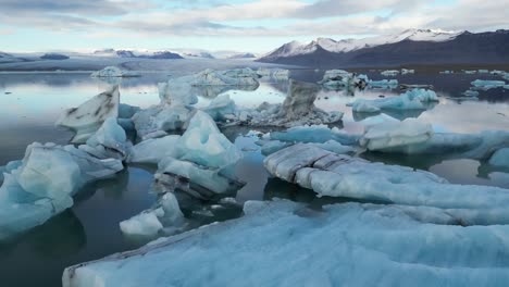 imagen de un avión no tripulado pasando por glaciares flotantes en islandia durante el invierno