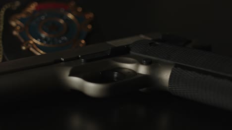 cinematic pan over pistol with a police badge in the background