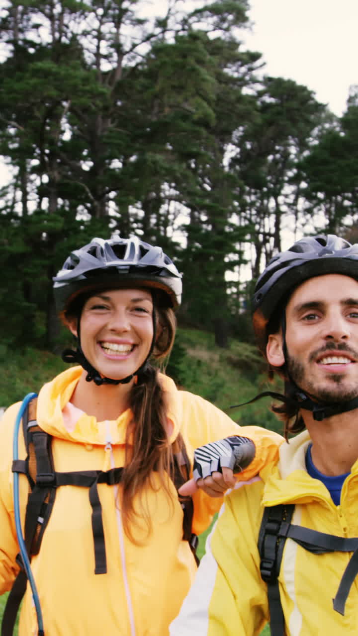pareja de ciclismo de montaña apuntando a la naturaleza