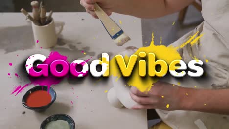 animation of good vibes text over hands of caucasian man painting pottery