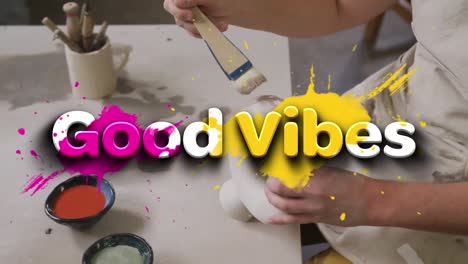 animation of good vibes text over hands of caucasian man painting pottery