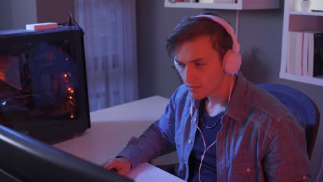 a focused young gamer is playing a video game on a personal computer.