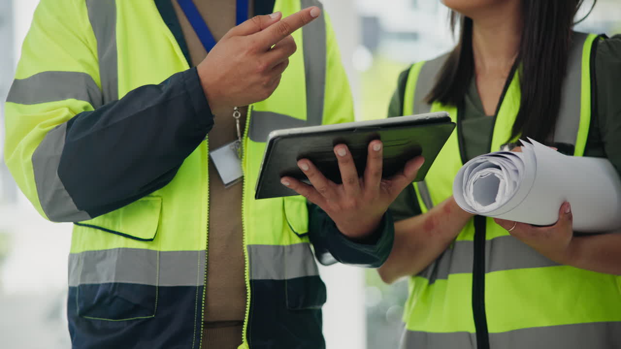 trabajadores de la construcción revisando planos con una tableta