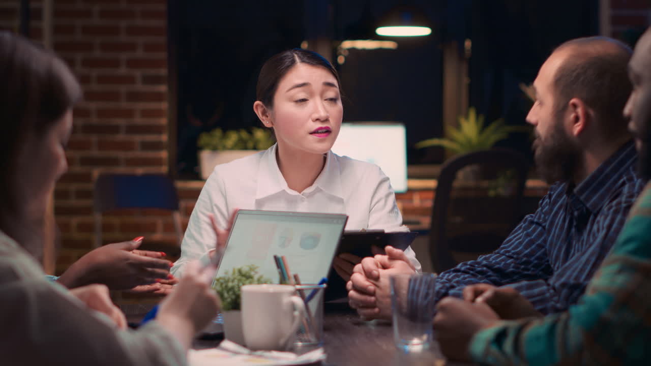 Asian woman speaking financial report in business meeting
