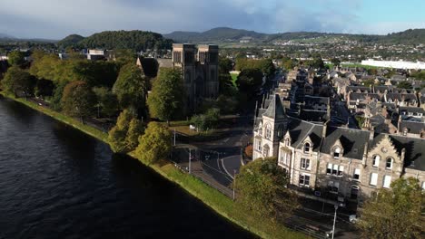 aerial drone footage of stone town homes and cathedral on ness river in inverness, scotland in the highlands