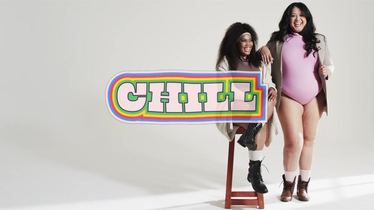 Dos mujeres posando en estudio, aparece un letrero 'CHILL' que se mueve, cubriendo sus cuerpos de forma sugerente para la moda.