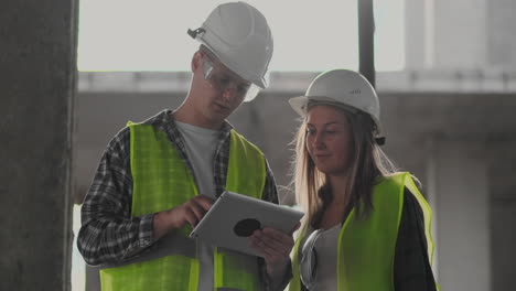 construction site team or architect and builder or worker with helmets discuss on a scaffold construction plan or blueprint or checklist