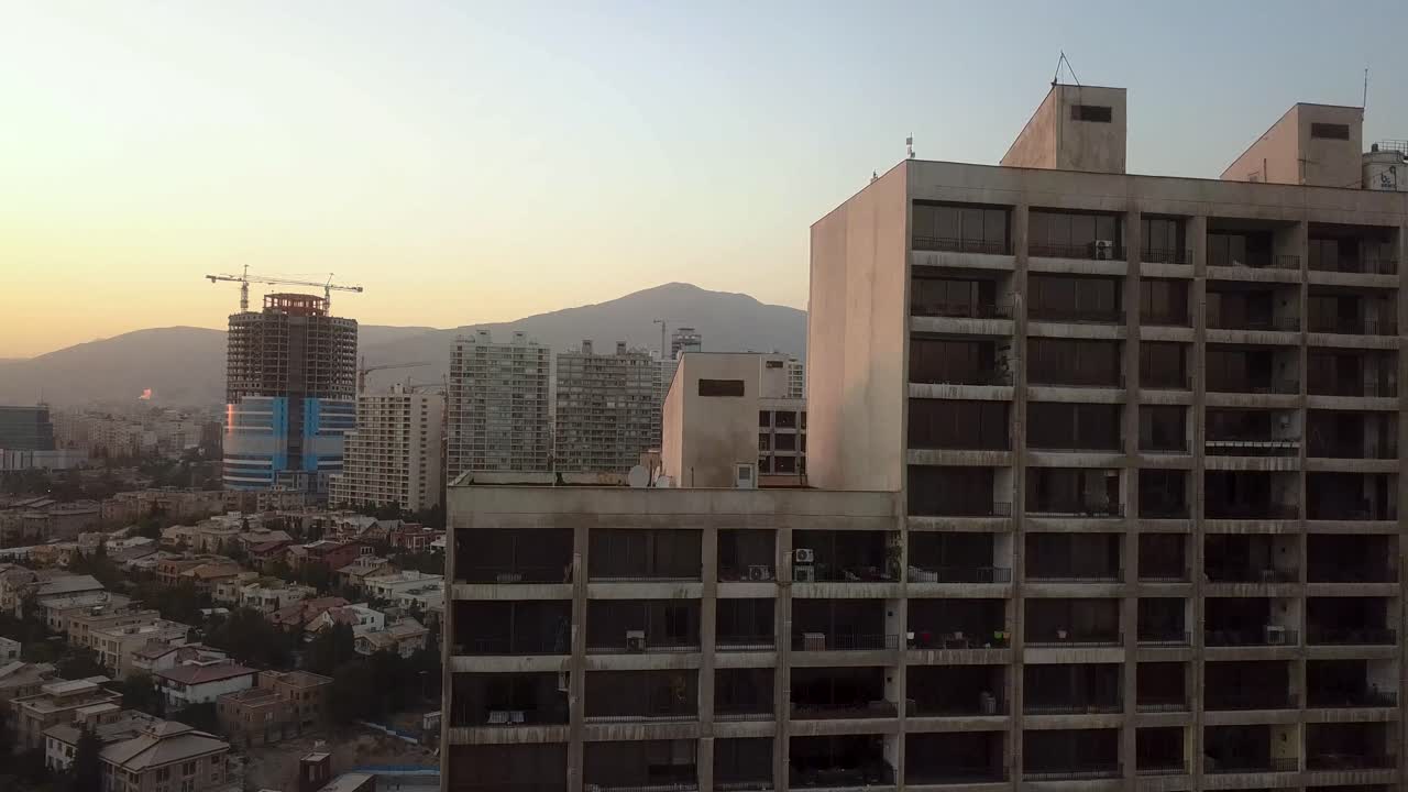 teherán irán disparo de drones subir tiro ascendente gran edificio en la ciudad tiempo dorado en la puesta del sol cielo despejado y montaña en el paisaje la gente vive en el apartamento de la torre concepto de riesgo de contaminación del aire calidad de vida de la ciudad