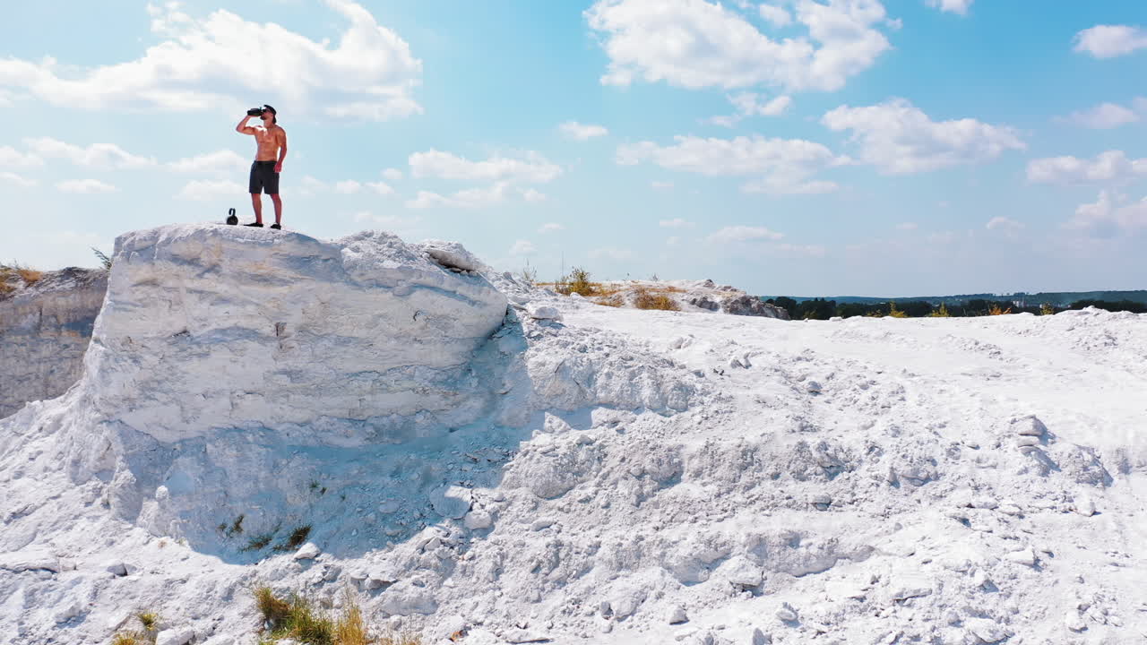 Man with Kettlebell on Top of a Hill