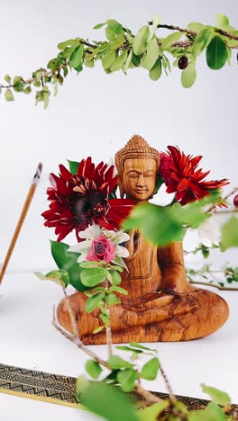 buddha statue with flowers and incense