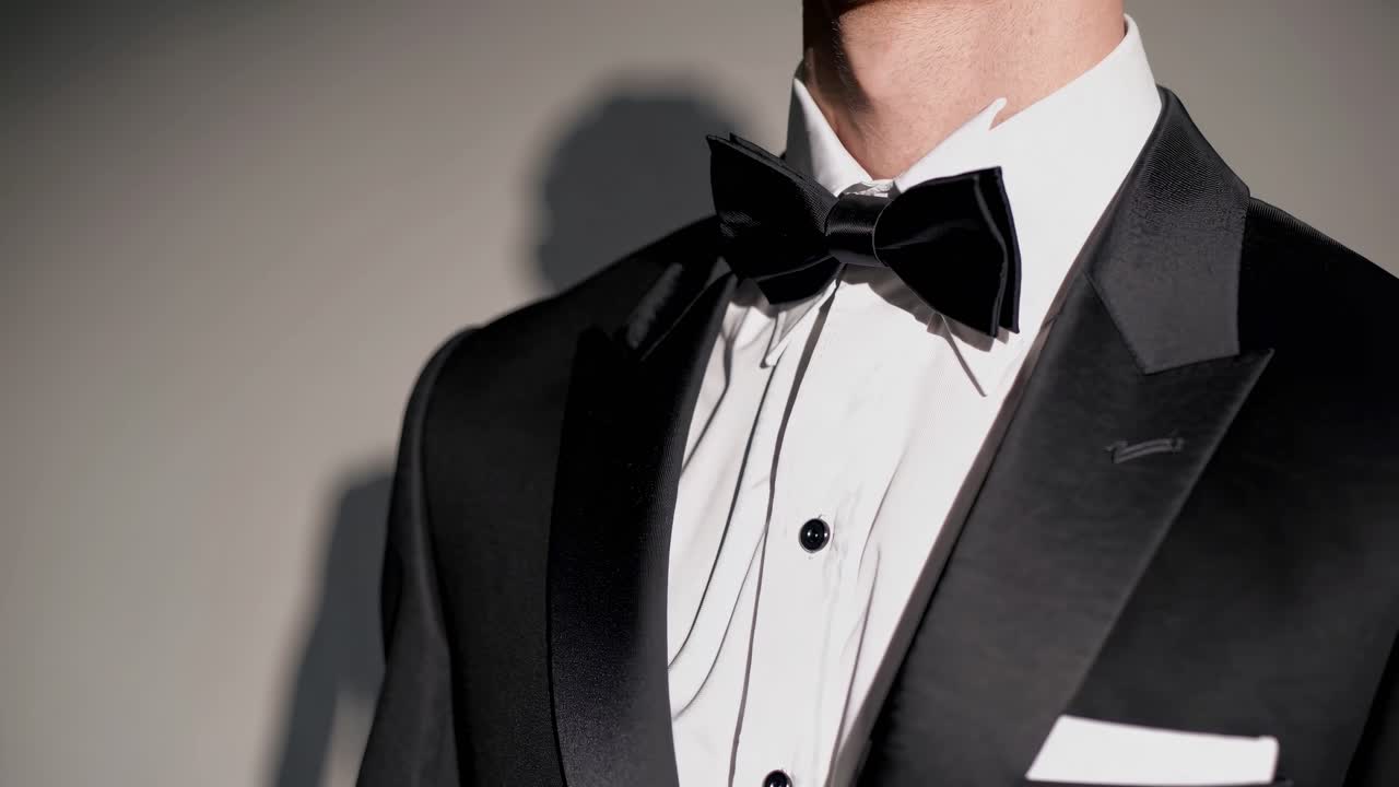 Primo piano di un video di un uomo in un classico smoking nero e papillon, che mette in mostra l'eleganza