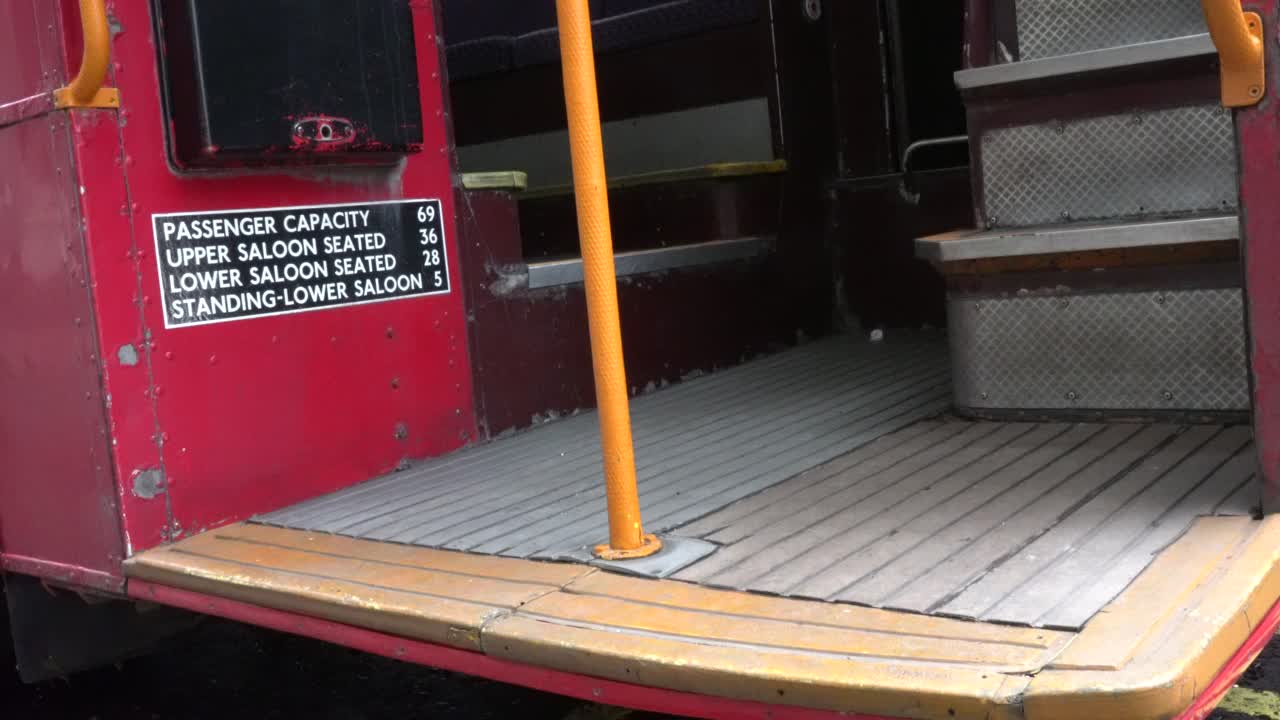 Man steps onto a stationary old London red bus