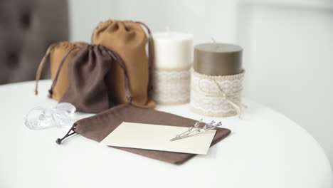 Beautiful-female-hand-writing-a-wedding-or-holiday-invitation-on-a-bright-white-table-with-candles