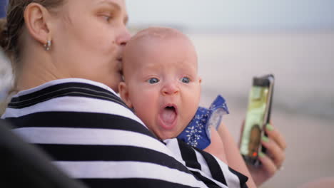 mum with baby having video chat on cell outdoor