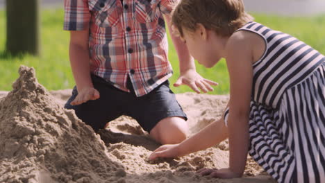 pupils at montessori school playing in sand pit at breaktime