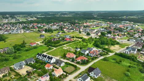 Aerial-view-of-a-suburban-residential-area-with-numerous-houses,-green-spaces,-and-roads