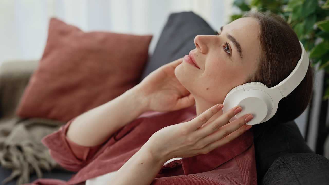 Woman Relaxing on Couch and Listening to Music