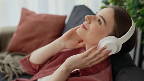 woman relaxing on couch and listening to music