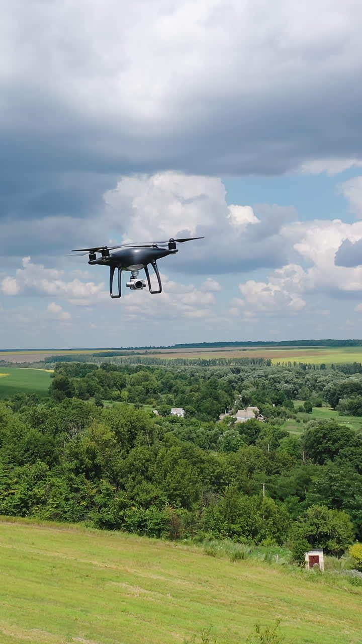 Electric drone flies in the sky. Drone quad copter with high resolution digital camera in the sky. Vertical video