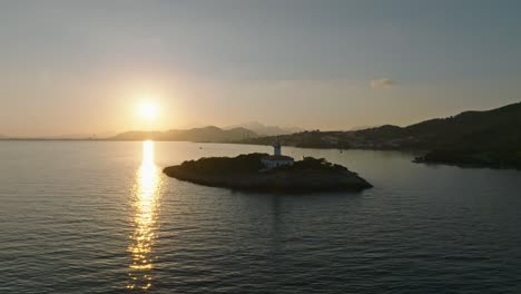 Backlit-Alcanada-lighthouse-at-sunrise-in-Spain,-sunlight-shines-across-ocean-water