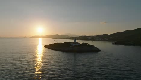 backlit alcanada lighthouse at sunrise in spain, sunlight shines across ocean water