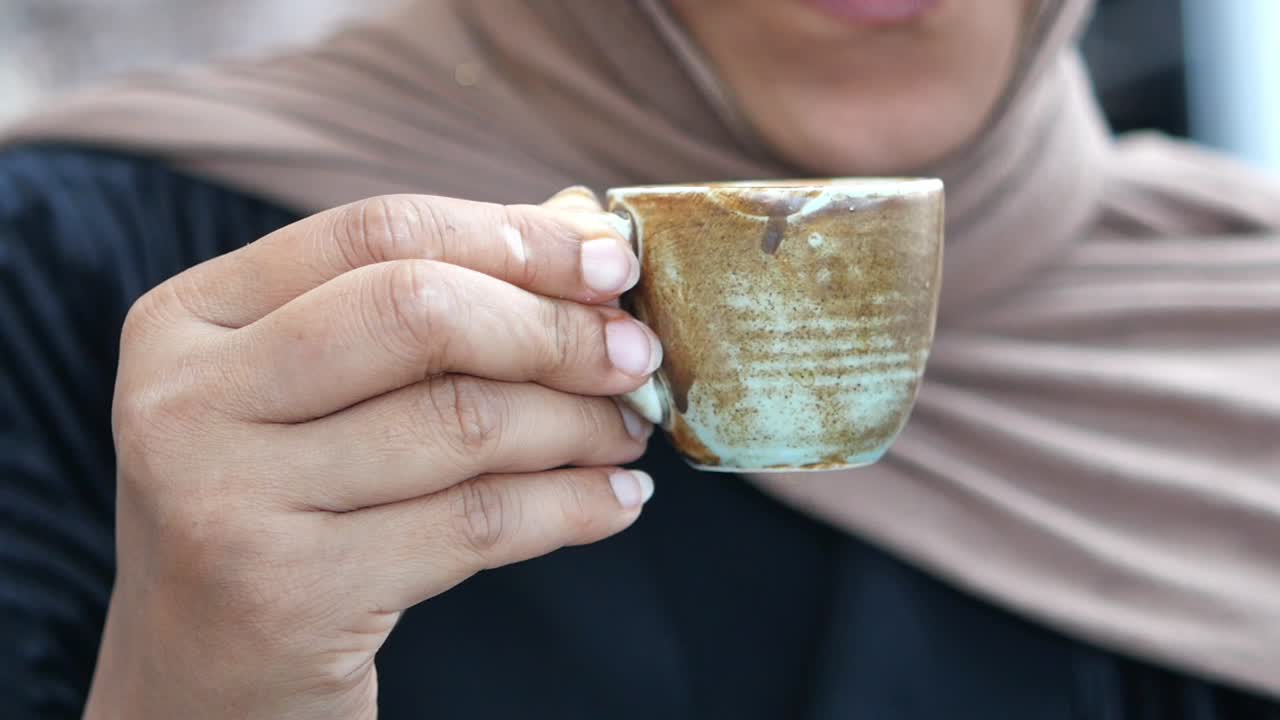 Woman holding a small coffee cup