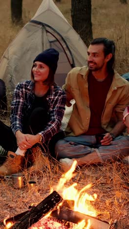 friends camping around campfire