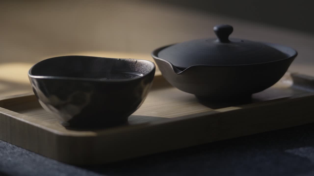 Pouring hot water into a tea bowl. Preparing traditional green Japanese tea in shiboridashi