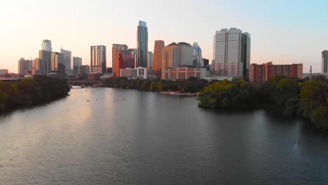 Cinematic-shot-of-austin-texas,-with-people-enjoying-the-lake,-and-a-bird-flying-majestically-across-the-screen