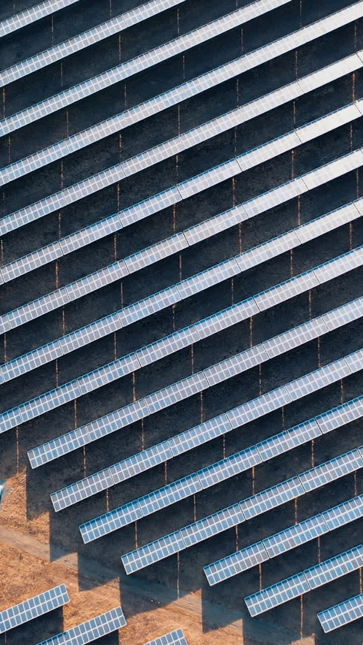 Solar power station panels in a row in the fields. Aerial view of solar power station. Landscape electrical power ecology innovation nature environment. Vertical video