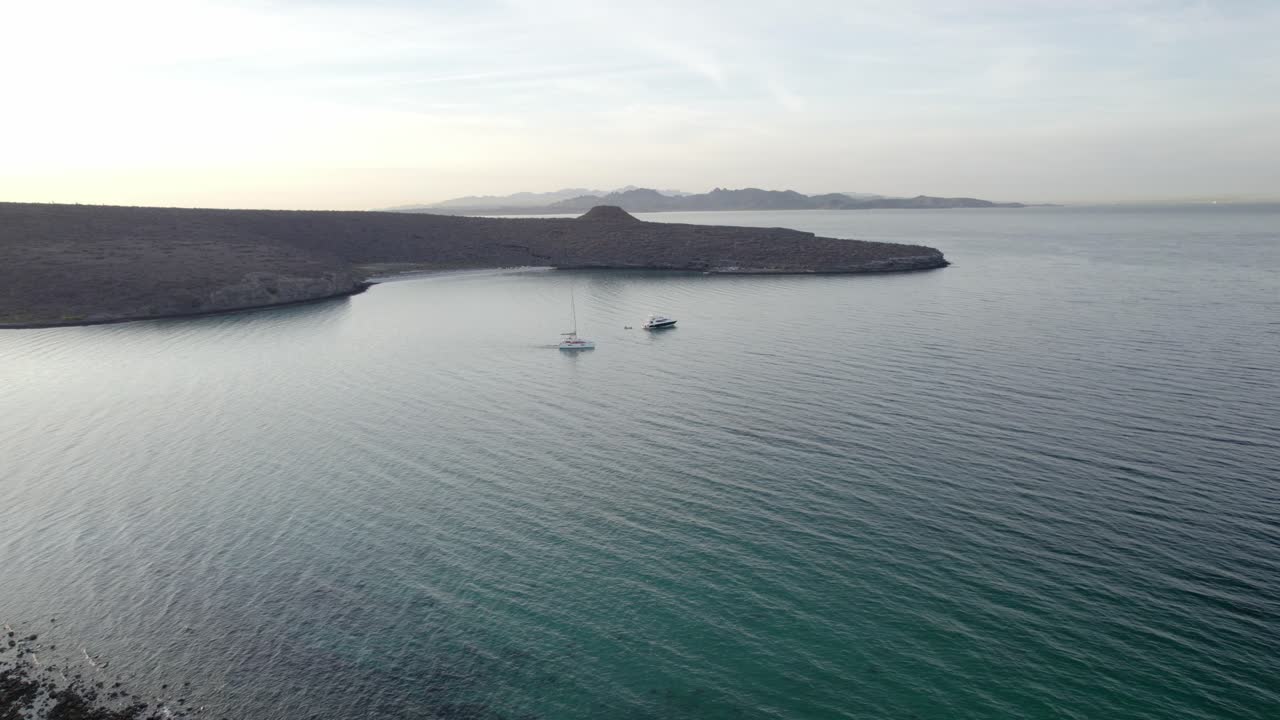 plano general aéreo de una isla con un yate y un catamarán