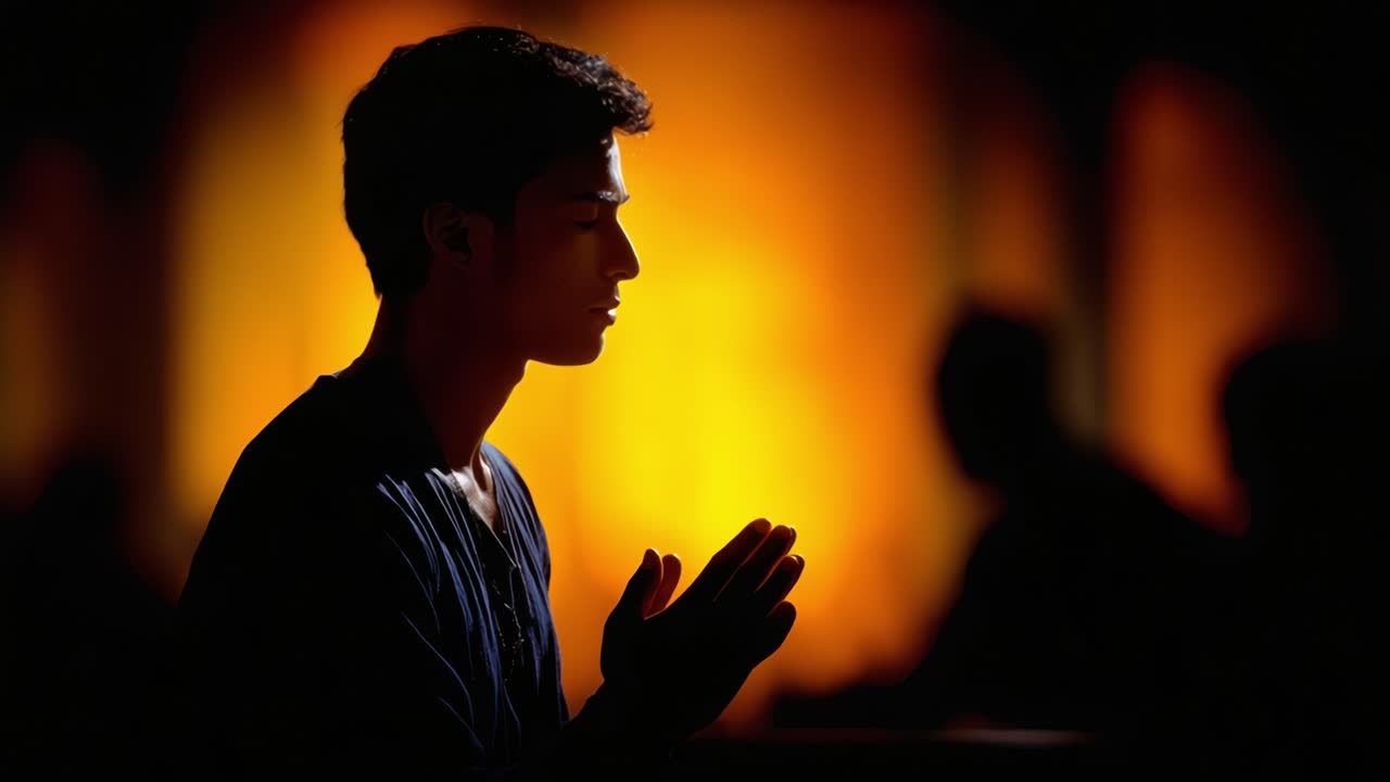 Un giovane uomo in contemplazione: silhouette su una luce calda, immerso in un momento di meditazione riflessiva e preghiera, circondato da ombre soffici