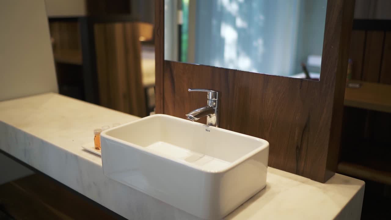 직사각형의 수영장, 우아한 수도꼭지, 목재 센트 를 가진 현대적 인 호텔 욕실 싱크대