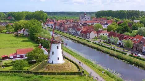 aerial over canal and small town of damme belgium and historic windmill 3