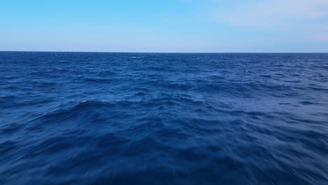 deep blue ocean water under a bright sky with subtle waves creating a peaceful and open seascape