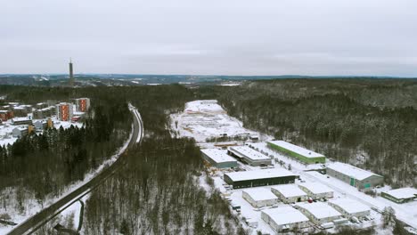 vista de pájaro de la carretera que recorre edificios y cabañas cubiertas de nieve