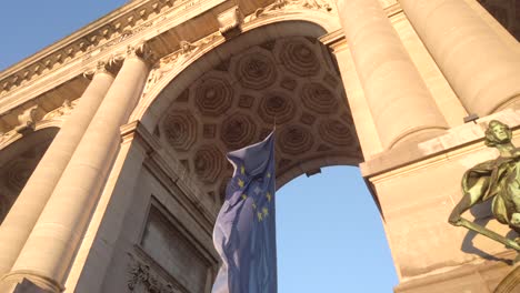 vertical eu flag beneath cinquantenaire columns
