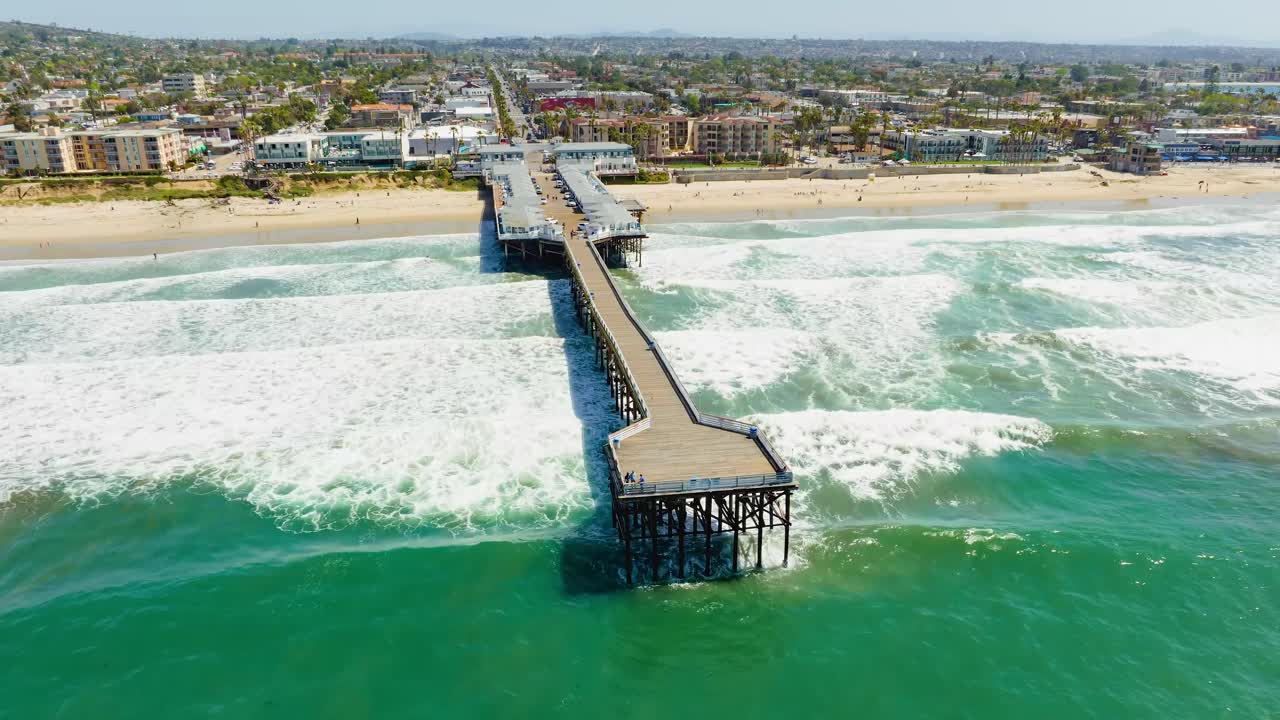Aerial view of Pacific Beach time lapse revealing sweeping coastline lined with sandy beaches over the pier