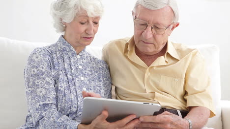 una pareja de ancianos usando una tableta.