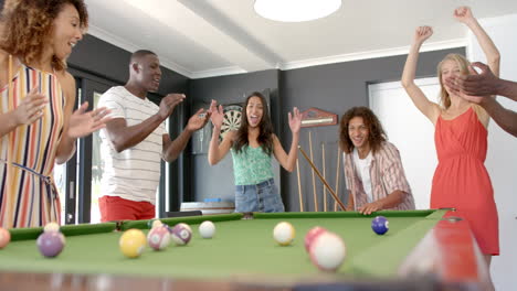 amigos diversos disfrutan de un juego de billar en casa