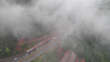 aerial birds eye view of muree expressway through misty foggy trees