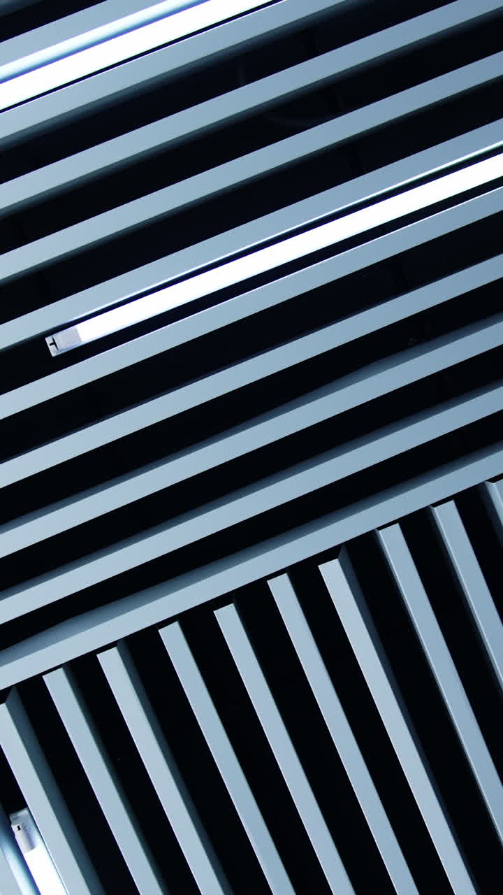 White day light lamps as the element of room decor. Unusual design of the ceiling with white planks and illumination. Vertical video