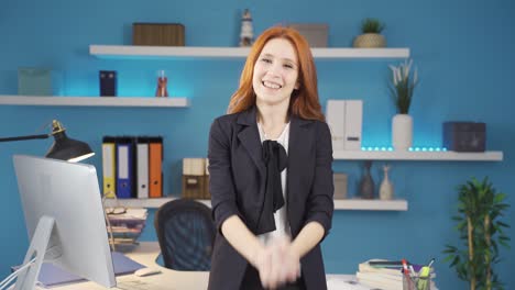 mujer de negocios regocijándose y mirando a la cámara.