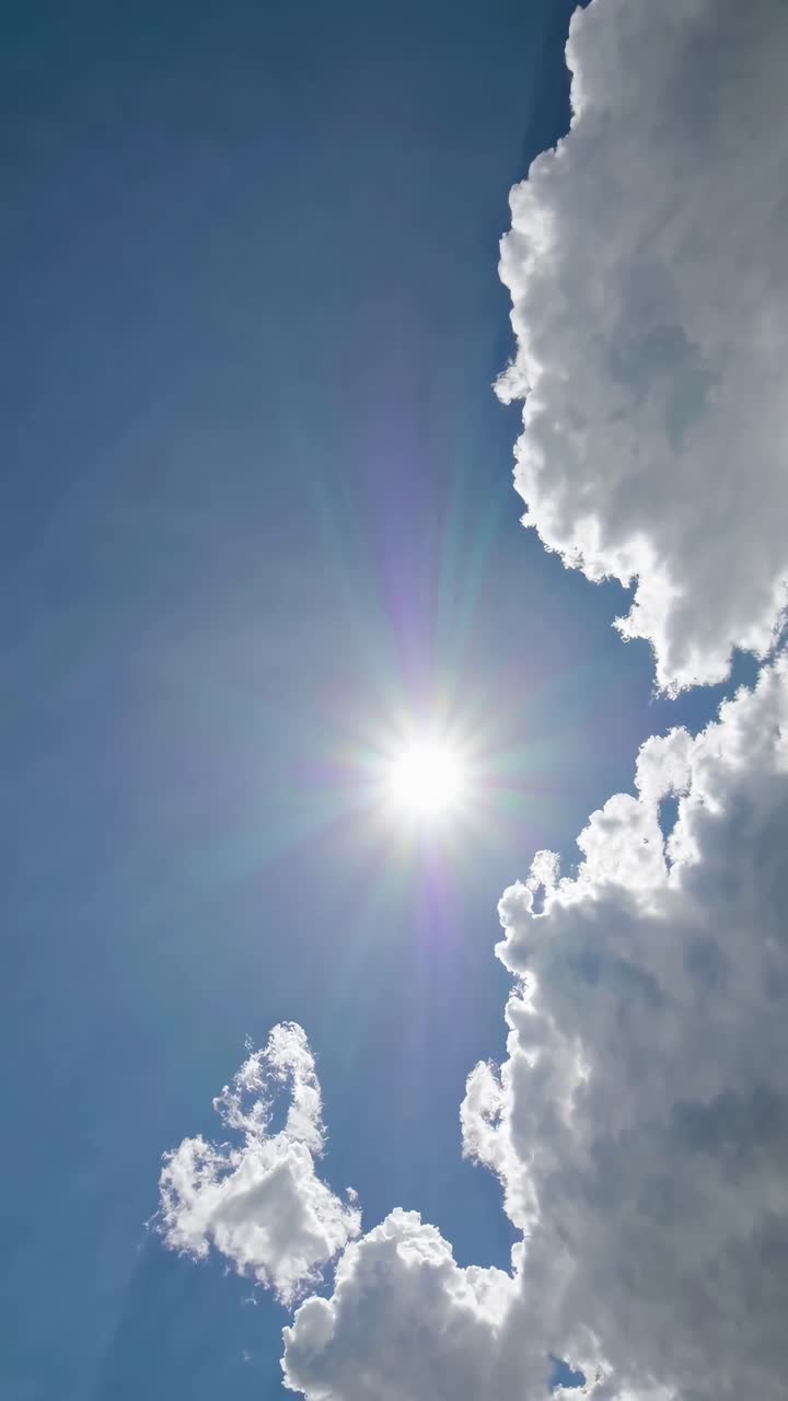 Upward angle captures sun and clouds in a serene sky, perfect for a calming video backdrop