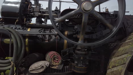 close-up of the side of a black vintage traction engine in operation