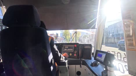 driver operating tram through sunny melbourne streets