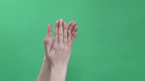 manos haciendo algunas figuras simbólicas en la llave de croma verde
