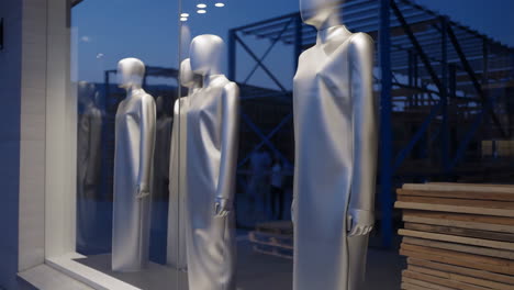 silver mannequins in storefront window
