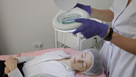 cosmetologist examining patient's face