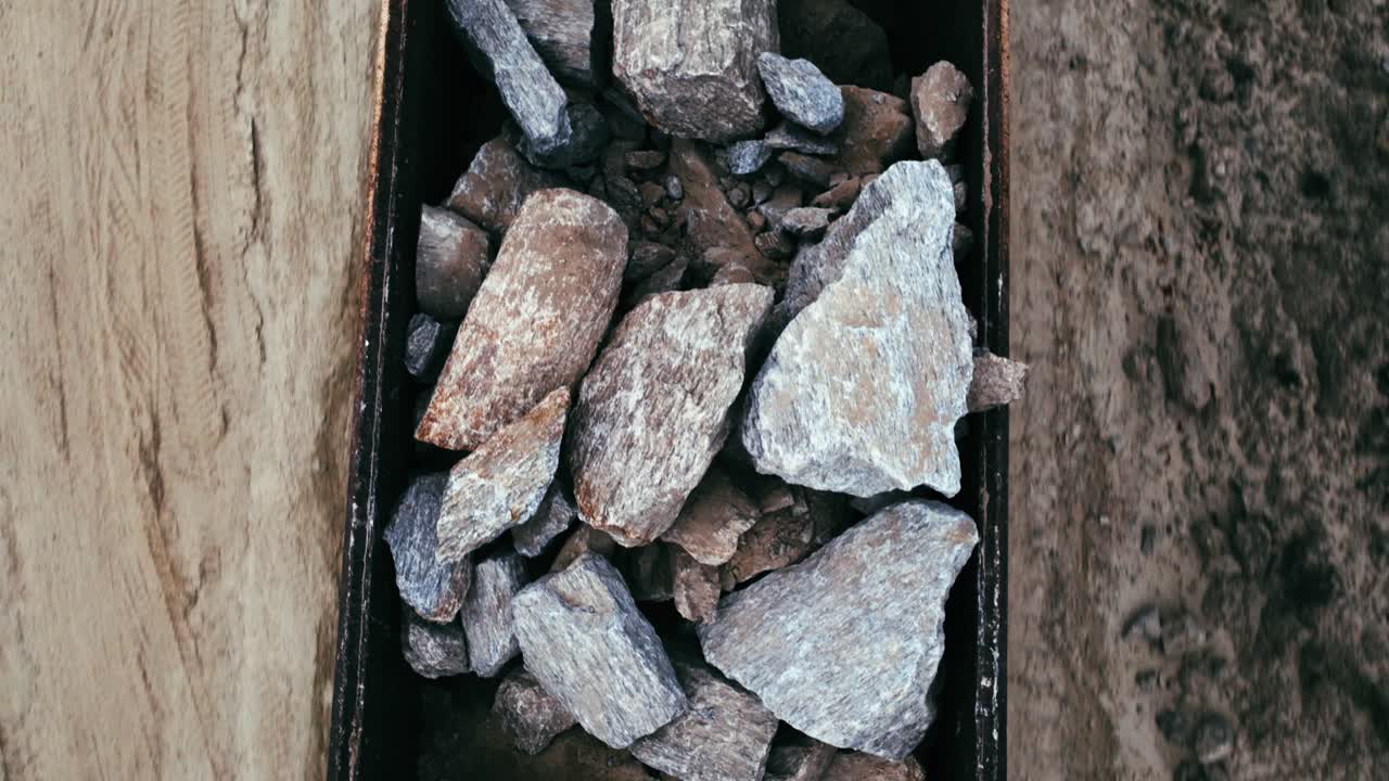 An aerial view of heavy rocks being transported in a large dump truck. top down aerial view